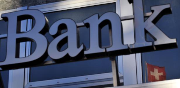 Banco em Genebra, com bandeira da Suíça ao fundo