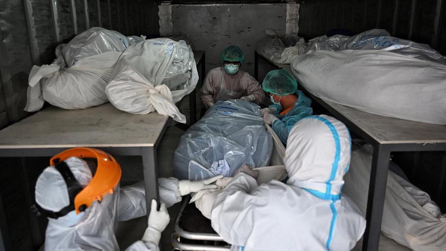 4.ago.2021 - Funcionários do hospital transferem os corpos de vítimas do coronavírus de um contêiner do lado de fora do Hospital Thammasat ao norte de Bangcoc, na Tailândia - Lillian SUWANRUMPHA/AFP