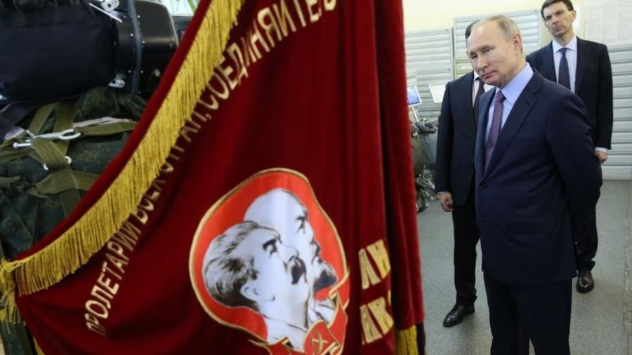 Presidente russo Vladimir Putin observa bandeira com retratos dos líderes soviéticos Vladimir Lenin e Joseph Stalin (foto de 06/03/2020) - Getty Images