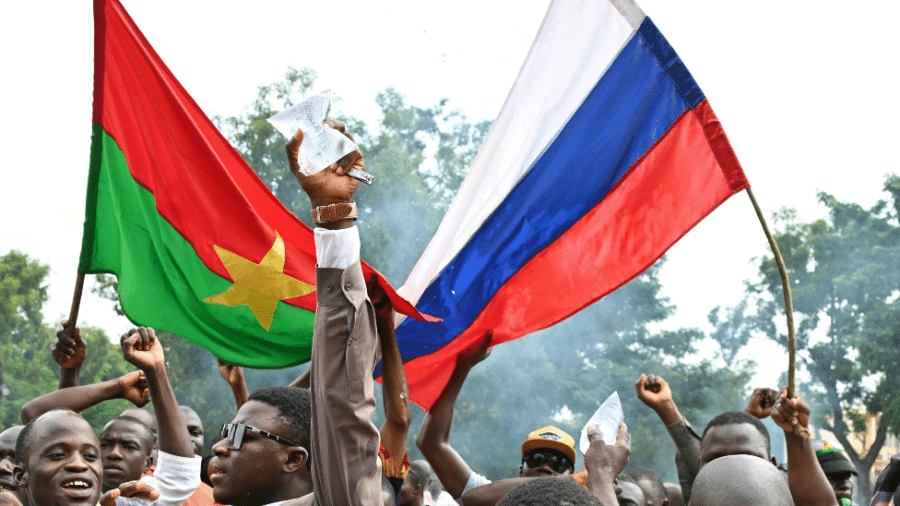 Apoiadores do novo líder da junta de Burkina Faso, Ibrahim Traoré, seguram bandeiras nacionais de Burkina Faso e da Rússia durante uma manifestação perto da sede estação nacional de rádio e televisão (RTB) em Ouagadougou, em 6 de outubro de 2022 - AFP