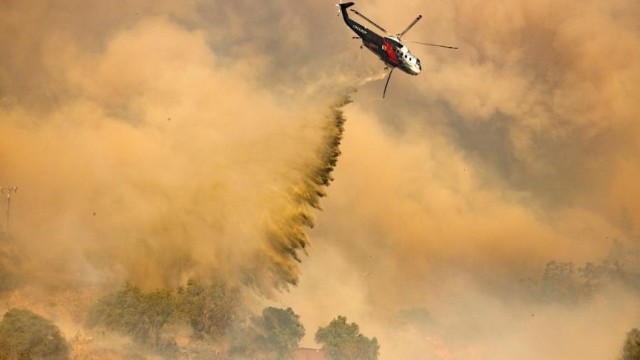 Um helicóptero de combate a incêndios faz um pouso sobre o Mountain Fire em Camarillo Heights, Camarillo, Califórnia, em 6 de novembro de 2024