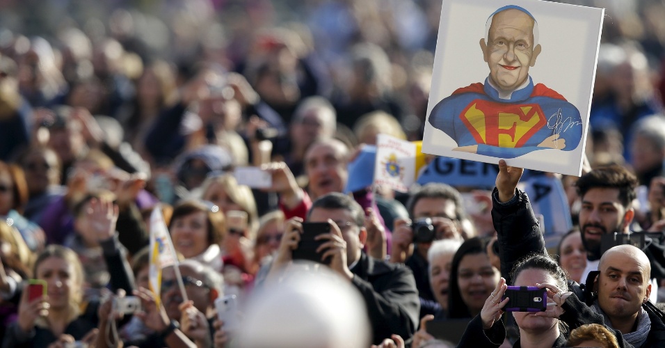 11.nov.2015 - Fiel ergue cartaz com imagem do papa Francisco vestido de Superman, durante audiência semanal na praça de São Pedro, no Vaticano