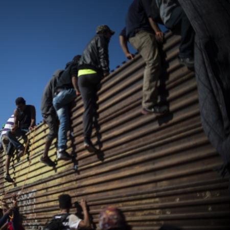 25.nov.18 - Grupo de imigrantes centro-americanos escalam o muro da fronteira entre México e EUA - Pedro Pardo/AFP