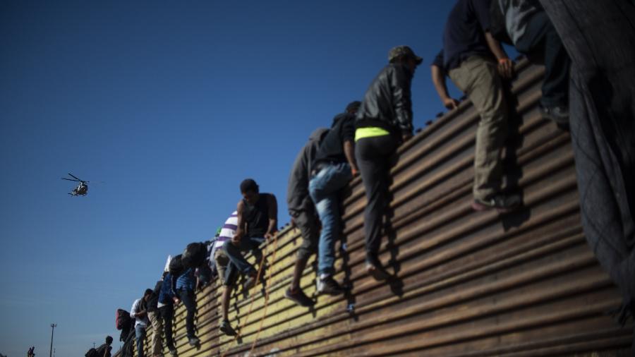 25.nov.18 - Grupo de imigrantes centro-americanos escalam o muro da fronteira entre México e EUA - Pedro Pardo/AFP