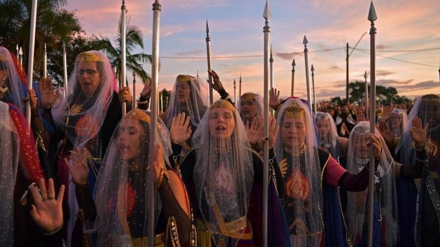 Mulheres devotas da comunidade religiosa Vale do Amanhecer, nos arredores de Planatina, a 50 km de Brasília, oram durante a maior cerimônia - CARL DE SOUZA/AFP