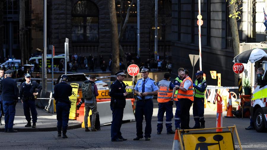 Policiais investigam o local onde um homem esfaqueou uma mulher e perseguiu outras no centro de Sydney, na Austrália - Saeed Khan/AFP