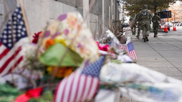 Membros da Guarda Nacional passam por um memorial improvisado após o ataque que deixou dois soldados baleados em Washington, em 28 de novembro de 2025
