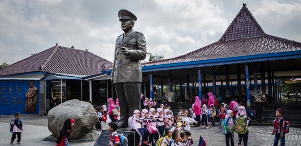 Estudantes posam ao lado da estátua do general Suharto em seu museu em Kemusuk, Indonésia - Ulet Ifansasti/The New York Times