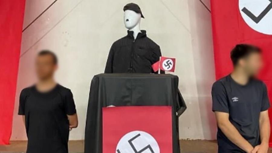 Imagens compartilhadas pela parlamentar Carol Dartora (PT-PR) nas redes sociais mostram alunos ao lado de um boneco com o bigode em referência ao ditador Adolf Hitler, além de faixas vermelhas com a suástica pregadas nas paredes