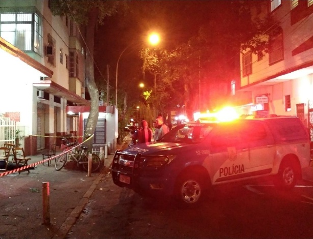 Carros da polícia estacionados na madrugada rua por onde homens passaram atirando - Bruno Aragaki/Colaboração para o UOL
