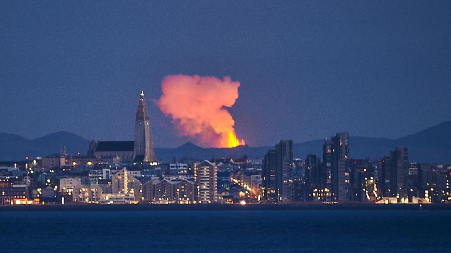 Foto de arquivo tirada em 5 de maio mostra o horizonte da capital da Islândia, Reykjavik, com o brilho da lava saindo de uma fissura do vulcão - Halldor KOLBEINS / AFP