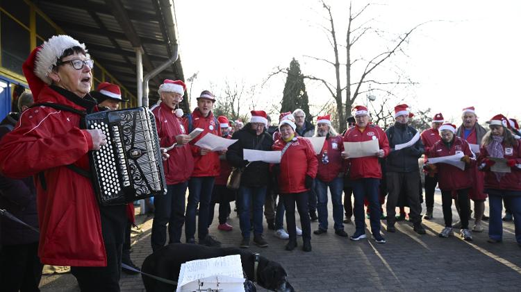 Pessoas fantasiadas e cantando músicas de Natal se preparam para enfrentar as temperaturas congelantes do Lago Orankesee no tradicional ?banho natalino?.