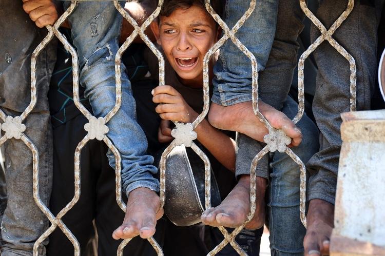 Garoto palestino espera distribuição de sopa de lentilha na Cidade de Gaza Garoto palestino espera distribuição de sopa de lentilha na Cidade de Gaza
