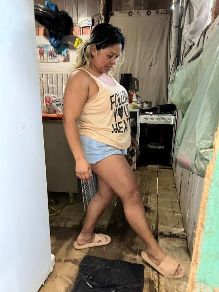 Arliane Nunes Pereira não tem acesso à água tratada em sua casa e, por falta de banheiro, improvisa "chuveiro" na sala