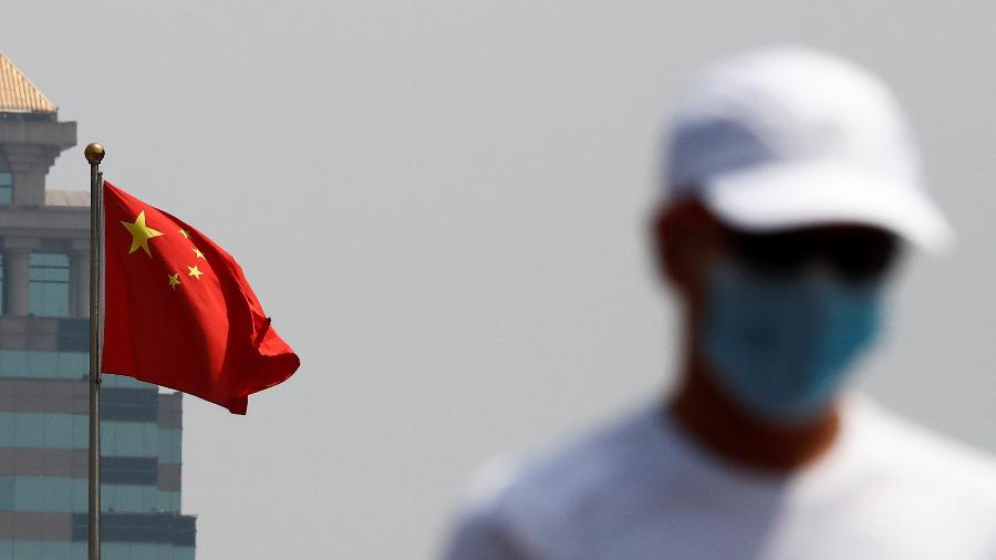 Homem com máscara de proteção caminha pelas ruas de Pequim - THOMAS PETER