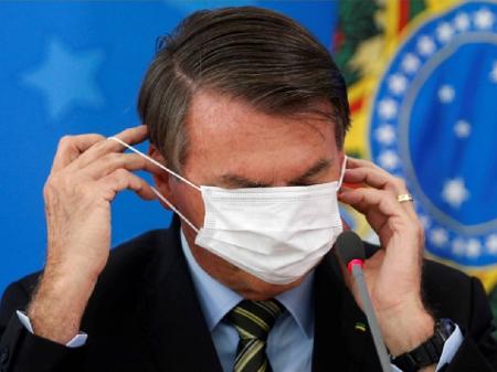 Bolsonaro cobre os olhos com máscara  - Adriano Machado/Reuters