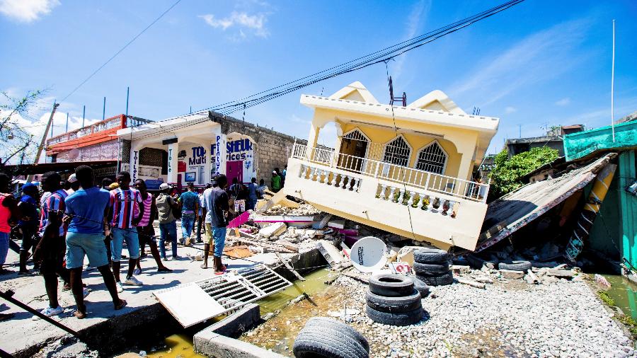 Pessoas do lado de uma casa destruída após um terremoto de magnitude 7,2 em Les Cayes, Haiti - Ralph Tedy/Reuters