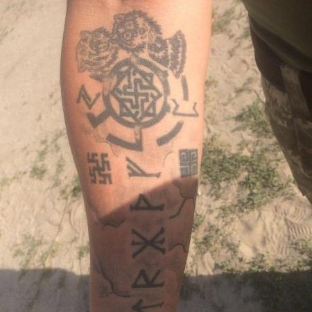 A man, described by experts as a British fighter in the service of the Ukrainian forces, displays a tattoo of neo-Nazi symbols on his right arm amid the conflict against Russia.