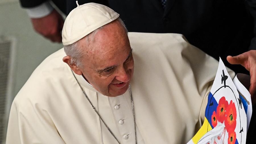13.abr.2022 - O Papa Francisco segura um desenho com a inscrição "Ucrânia" entregue a ele enquanto se reúne com os participantes durante a audiência geral semanal no Vaticano - Andreas Solaro/AFP