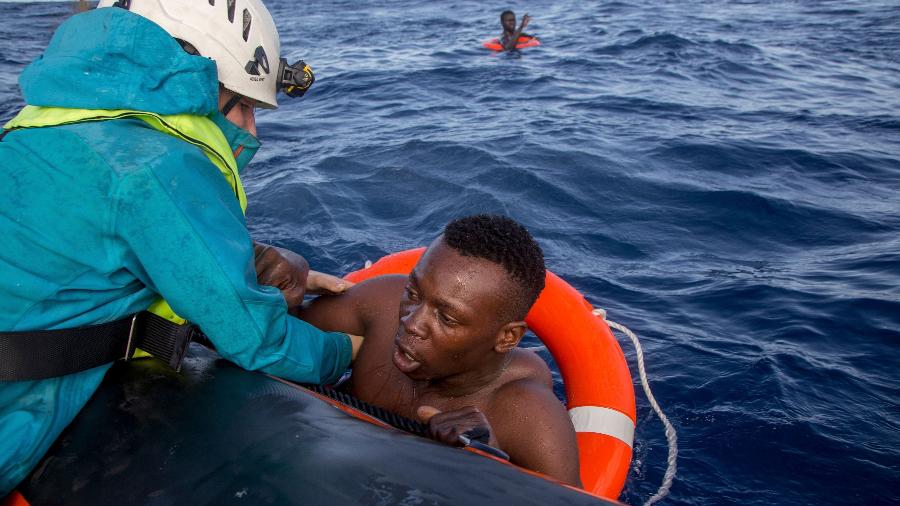 Migrante tenta subir no bote das equipes de resgate da ONG Sea Watch no mar Mediterrâneo em 2017 - Alessio Paduano/AFP