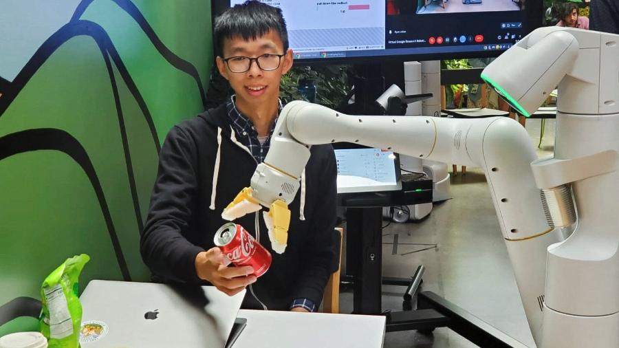 Pesquisador Fei Xia, do Google, aceita lata de refrigerante entregue por robô durante demonstração em cozinha da companhia na sede da empresa em Mountain View, na Califórnia (EUA) - Paresh Dave/Reuters