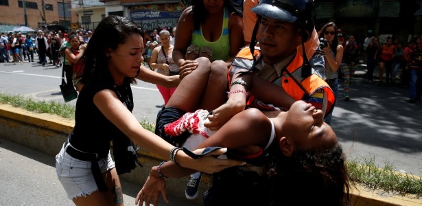 Imagem de arquivo mostra policial carregando uma mulher que desmaiou durante confusão para tentar comprar massas fora de um supermercado em Caracas, Venezuela - Carlos Garcia Rawlins/Reuters