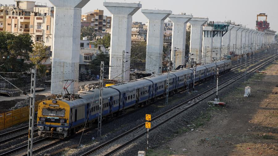 Um trem passa pelo corredor elevado em construção do trem-bala Ahmedabad-Mumbai, nos arredores de Ahmedabad, Índia