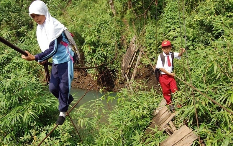 Indonésia - Estudantes de uma vila da ilha de Sumatra, Indonésia, precisam atravessar uma ponte de cordas, suspensa a uma altura de cerca de dez metros, para chegar à escola. A ponte fixa havia sido destruída e não foi reconstruída
