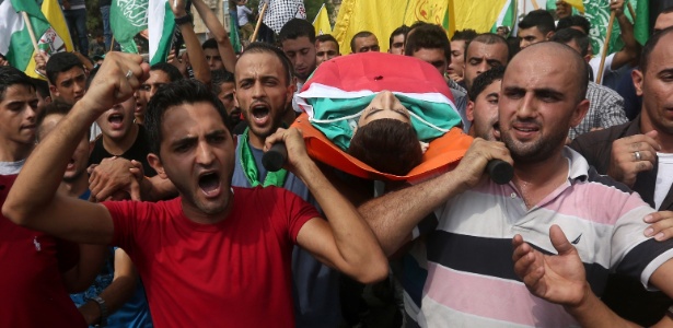 Homens carregam o corpo de Huzeifa Othman Suleiman, jovem palestino de 18 anos que foi morto durante confrontos com Exército israelense em Tulkarem, na Cisjordânia