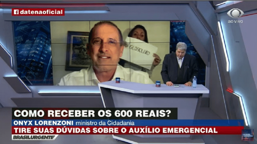 Um cartaz com crítica à Globo apareceu durante entrevista do ministro Onyx Lorenzoni a José Luiz Datena, na Band - Reprodução