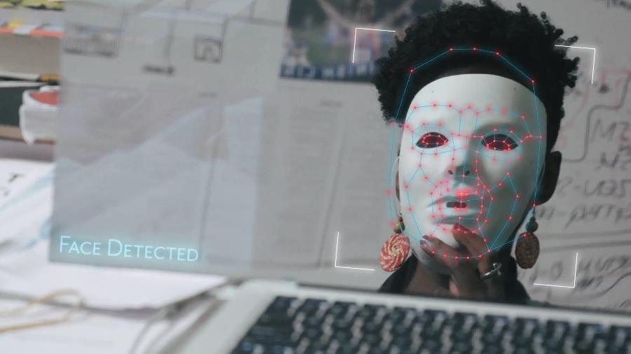 Joy Buolamwini usa uma máscara para testar software de reconhecimento facial em cena do documentário "Coded Bias" - Divulgação