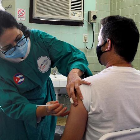 A enfermeira Xiomara Rodriguez aplica vacina, a Soberana 2, a um voluntário durante seu ensaio de Fase III em Havana, em 31 de março de 2021. - Joaquín HERNANDEZ/AFP