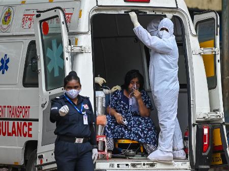 Paciente com covid-19 é transportada em ambulância em Mumbai, na Índia - Punit Paranjpe/AFP