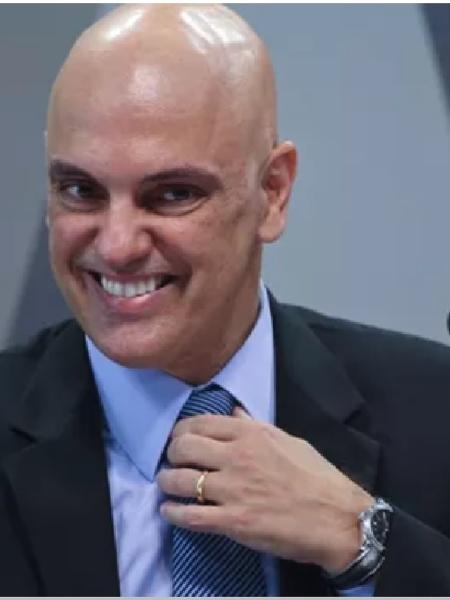 Alexandre de Moraes sorrindo e ajeitando a gravata - Aílton de Freitas/O Globo