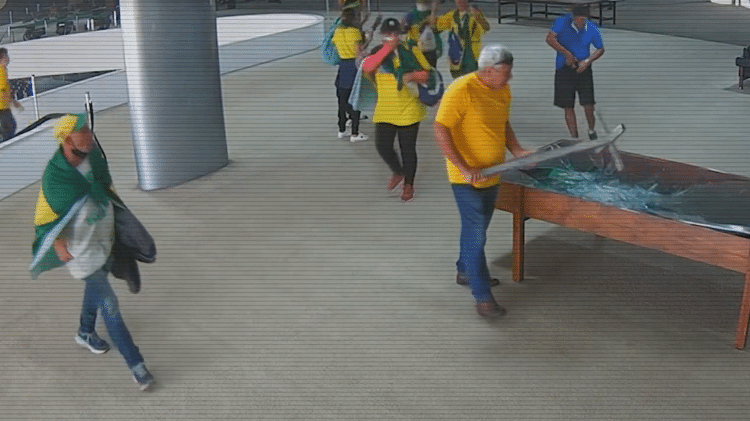 Homem com camiseta do Brasil quebra o vidro da mesa com documentos hist�ricos que fica no mezanino do Pal�cio do Planalto - Reprodu��o/ TV Globo - Reprodu��o/ TV Globo
