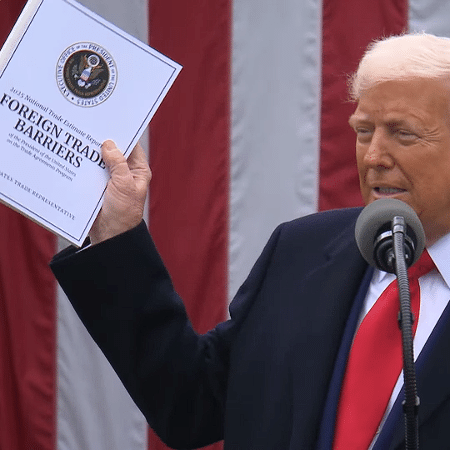 Trump segura "livro do tarifaço", com taxas de importação que serão cobradas dos países Trump segura "livro do tarifaço", com taxas de importação que serão cobradas dos países