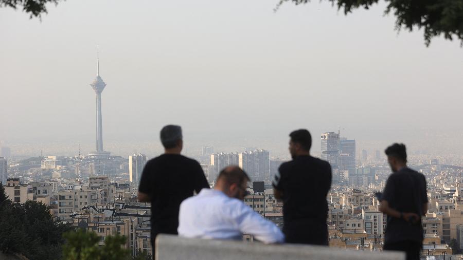 Homens observam a paisagem urbana após os ataques israelenses em Teerã, Irã Homens observam a paisagem urbana após os ataques israelenses em Teerã, Irã