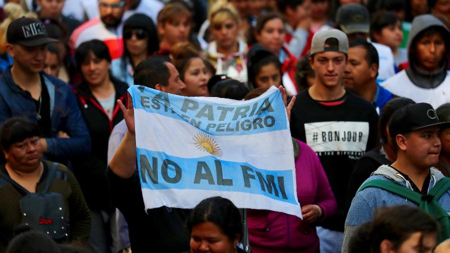 Manifestante segura bandeira da Argentina com os dizeres "Nossa pátria está em pergigo. Não ao FMI (Fundo Monetério Internacional)". Foto de arquivo de 2018 - Marcos Brindicci/Reuters