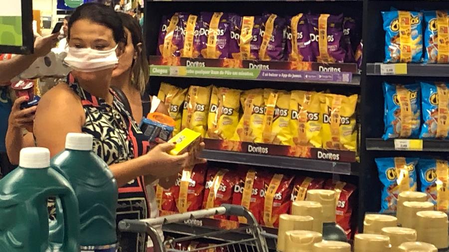 19.mar.2020 - Mulher com máscara de proteção faz compras em supermercado - Herculano Barreto Filho/UOL