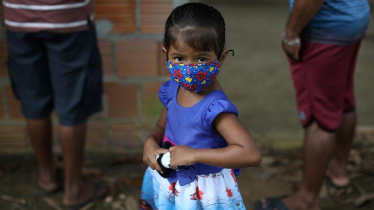 Criança com máscara protetora espera ser testada para a doença de coronavírus (COVID-19) na Bela Vista do Jaraqui - BRUNO KELLY/REUTERS - BRUNO KELLY/REUTERS