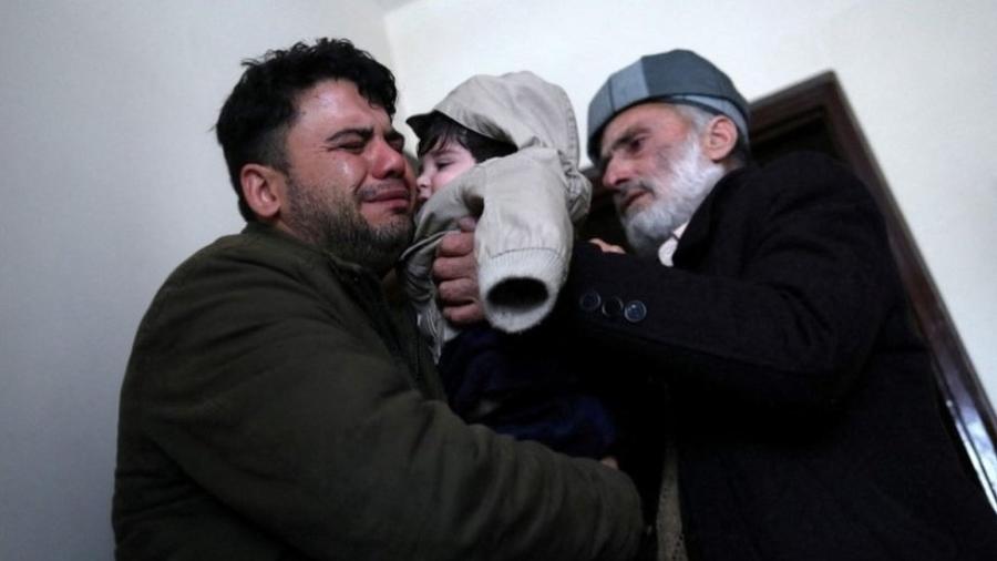 Hamid Safi, o taxista de 29 anos que encontrou o bebê no aeroporto, chora ao entregar Sohail ao avô - Reuters