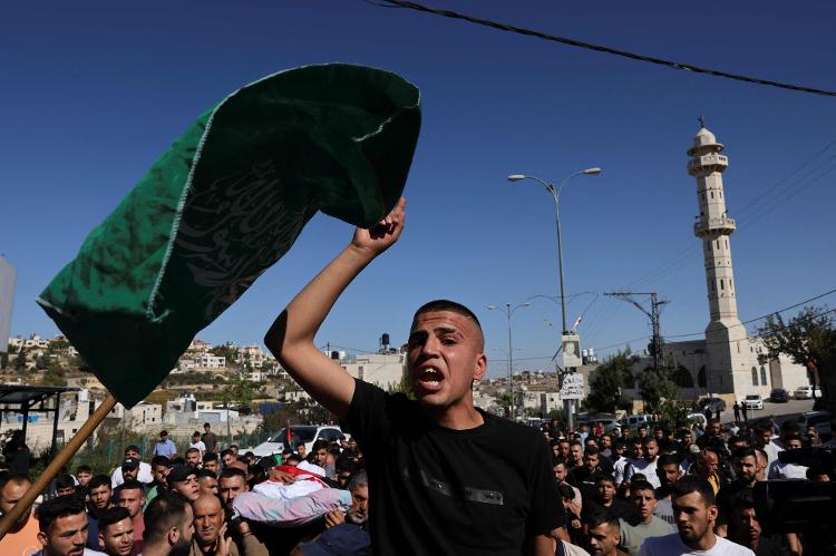 Jovem palestino agita bandeira islâmica 