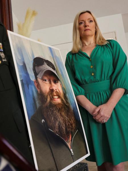 Stacey Wales ao lado de um quadro com uma imagem do irmão, Chris Pelkey, morto em uma briga de trânsito em 2021 - Liliana Salgado/Reuters