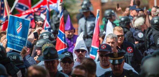 Centenas de homens e mulheres carregam tochas, fazem saudações nazistas e gritam palavras de ordem contra negros, imigrantes, homossexuais e judeus em Charlottesville - AFP