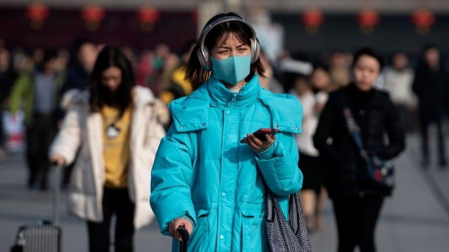 Chineses usam máscaras para tentar evitar a propagação do novo vírus que já matou 6 pessoas no país - AFP