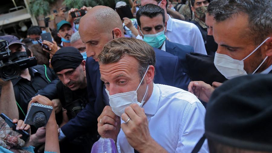Presidente Emmanuel Macron ajusta máscara durante sua visita a Beirute, acompanhada por uma multidão - AFP