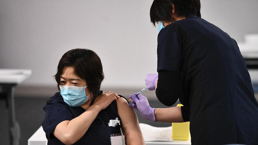 17.fev.2021 - Profissional da saúde recebe dose da vacina da Pfizer/BioNTech contra covid-19 no Hospital Chiba Rosai em Ichihara, no Japão - Kazuhiro Nogi/AFP