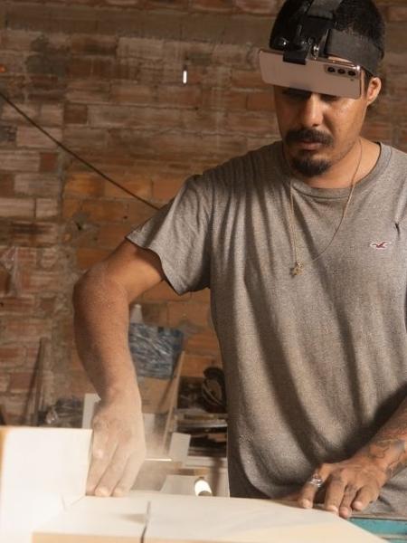 Homem fazendo trabalho de marcenaria gravando o procedimento com um celular preso a um suporte na cabeça Homem fazendo trabalho de marcenaria gravando o procedimento com um celular preso a um suporte na cabeça