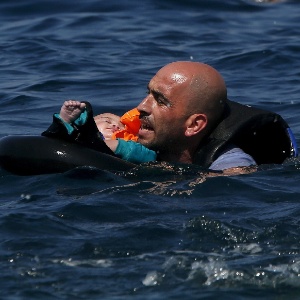 Refugiado segura bebê após naufrágio da embarcação que os levava para a ilha de Lesbos - Alkis Konstantinidis/Reuters