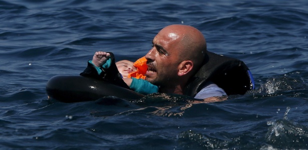 Refugiado sírio segura bebê após naufrágio da embarcação que os levava para a ilha de Lesbos, na Grécia - Alkis Konstantinidis/Reuters